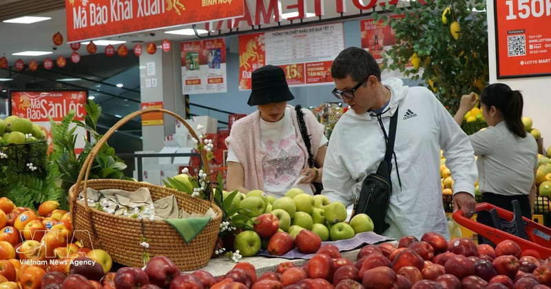 Extranjeros compran frutas en un mercado vietnamita. (Fuente: VNA)