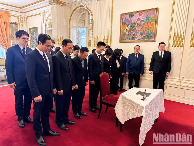 El encargado de negocios interino Pham Quang Anh, funcionarios de la Embajada y representantes de entidades vietnamitas en Francia guardan un minuto de silencio en memoria del camarada Saysomphone Phomvihane. (Foto: Trung Hung).
