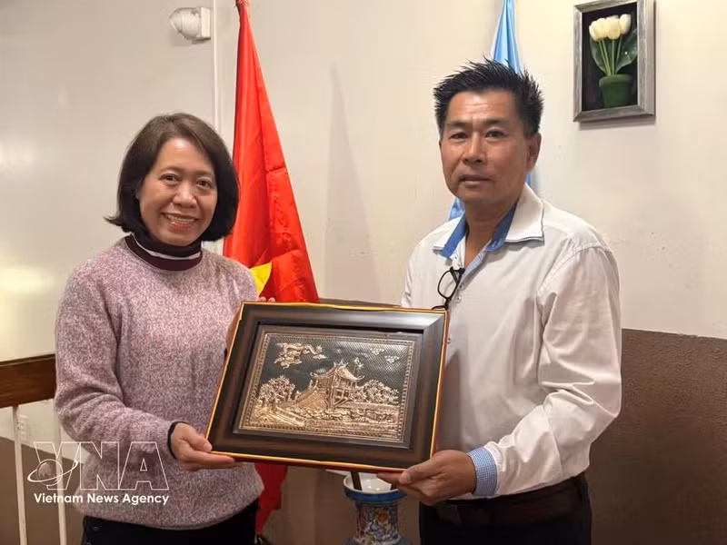 La embajadora Ngo Minh Nguyet entrega obsequio un representante de la comunidad de vietnamitas residentes en Posadas. (Foto: VNA)