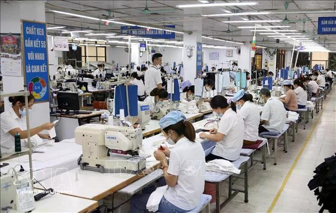 Trabajadores de una fábrica textil que exporta productos en Garco 10 en Hanói. (Foto: VNA)