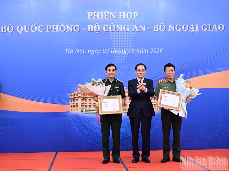 El ministro de Relaciones Exteriores, Le Hoai Trung, entrega las medallas conmemorativas a la causa de la diplomacia vietnamita al vicepremier y ministro de Defensa, general Phan Van Giang, y al ministro de Seguridad Pública, general Luong Tam Quang. (Foto: Nhan Dan)