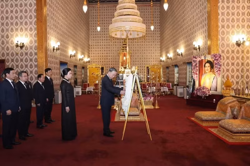 El secretario general del Partido Comunista y presidente de Vietnam, To Lam, junto con su esposa, colocan una ofrenda floral y firman el libro de condolencias en homenaje a la Reina Madre Sirikit de Tailandia.