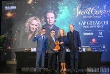 El grupo musical Secret Garden obsequia un violín al comité organizador del programa “Secret Garden Live in Vietnam”.