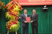 Le Minh Hung, miembro del Buró Político, secretario del Comité Central del PCV y jefe de su Comisión de Organización, felicita a Nguyen Dinh Trung (Foto: VGP)