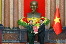 El presidente Luong Cuong entrega la decisión de nombramiento para el cargo de jefe de la Dirección General de Política del Ejército Popular de Vietnam y, al mismo tiempo, asciende al camarada Nguyen Trong Nghia del rango de Teniente General al de General.