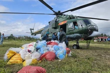 Un helicóptero militar lanza suministros de socorro a una zona afectada por las inundaciones. (Foto: Nhan Dan)