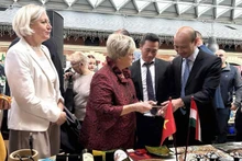 El embajador de Vietnam en Hungría, Bui Le Thai, presenta a los invitados los productos vietnamitas expuestos en la feria. (Foto: Embajada de Vietnam en Hungría)