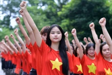 Jóvenes vietnamitas organizan simultáneamente ceremonia de saludo a la bandera 'Amo a mi Patria'. (Foto: Nhan Dan)