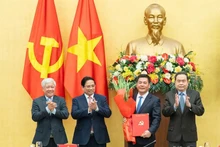 El primer ministro Pham Minh Chinh (segundo desde la izquierda) y el presidente de la Asamblea Nacional Tran Thanh Man (extrema derecha), entregan la decisión del nombramiento y ofrecen flores a Nguyen Hong Dien. (Foto: Nhan Dan)