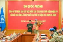 El miembro del Comité Central del Partido Comunista de Vietnam y viceministro de Defensa, teniente general Hoang Xuan Chien, entrega la decisión del Presidente de la República al oficial designado a una misión de mantenimiento de la paz de la Organización de las Naciones Unidas. (Foto: Nhan Dan)