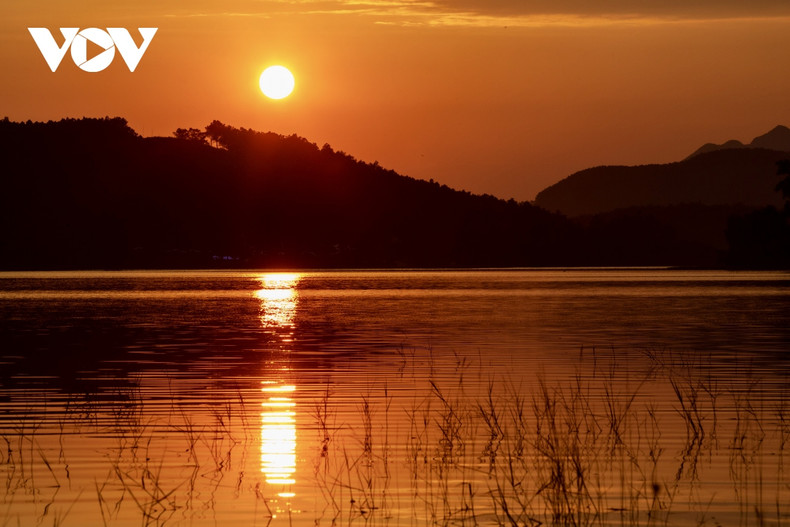 Escena poética de puesta del sol en el lago de Yen Trung.