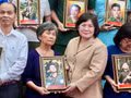 Van Thi Bach Tuyet, vicesecretaria del Comité del Partido Comunista de Vietnam en Ciudad Ho Chi Minh, entrega retratos restaurados de combatientes caídos a sus familiares. (Foto: Nhan Dan)