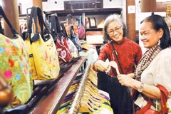 Turistas compran productos en una tienda de productos de la aldea de Van Phuc. (Foto: Nhan Dan)