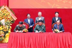 El secretario general del Partido Comunista, To Lam, el presidente, Luong Cuong, y el primer ministro, Pham Minh Chinh, presencian la firma de las nuevas normas de coordinación entre los Ministerios de Seguridad Pública, de Defensa y de Relaciones Exteriores el 6 de diciembre. (Foto: VNA)