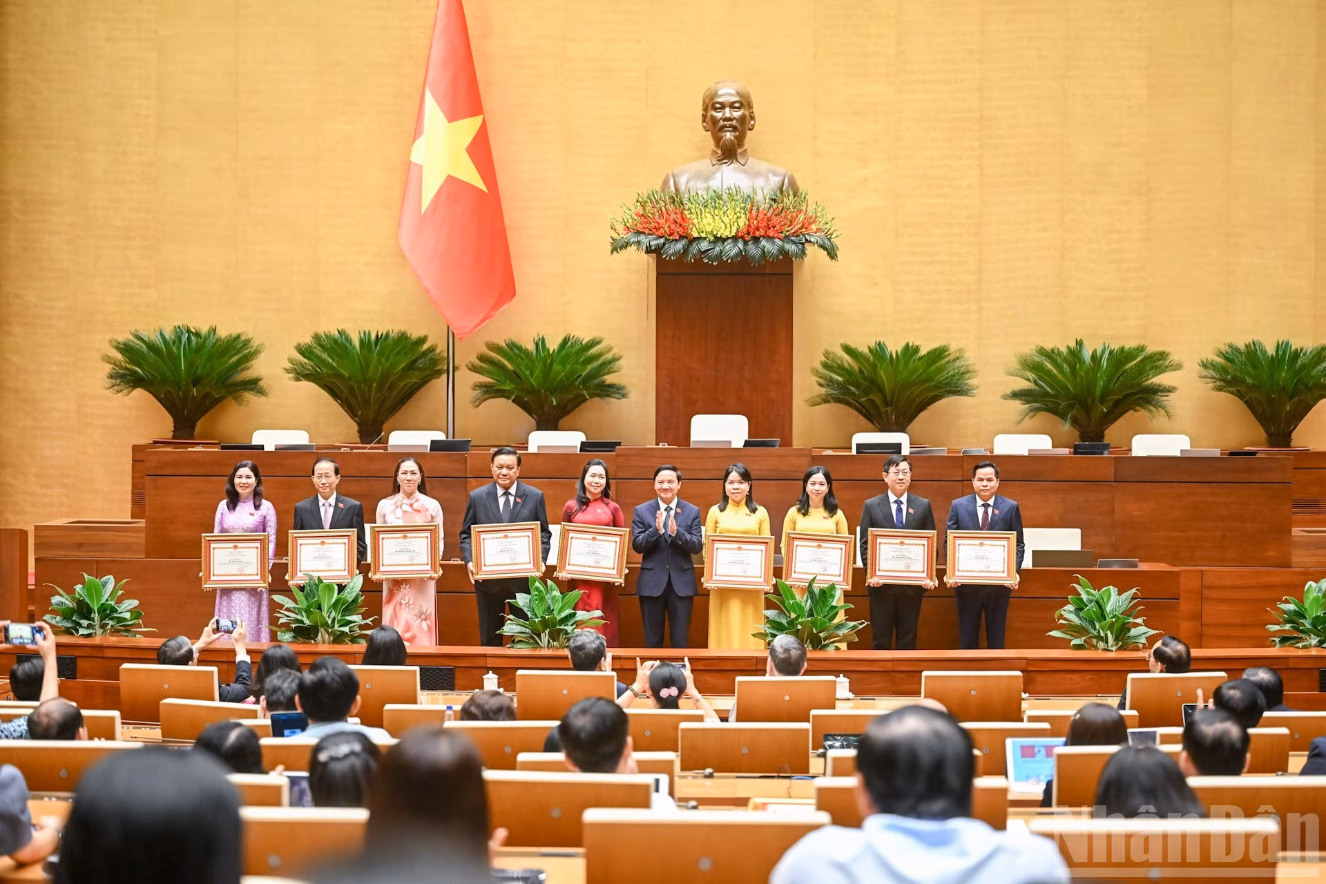 El vicepresidente de la Asamblea Nacional Nguyen Khac Dinh entrega certificados de mérito a los destinatarios.