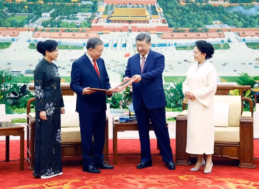 El secretario general del Partido Comunista y presidente de China, Xi Jinping, y su esposa, obsequian un álbum fotográfico al dirigente vietnamita y su esposa.