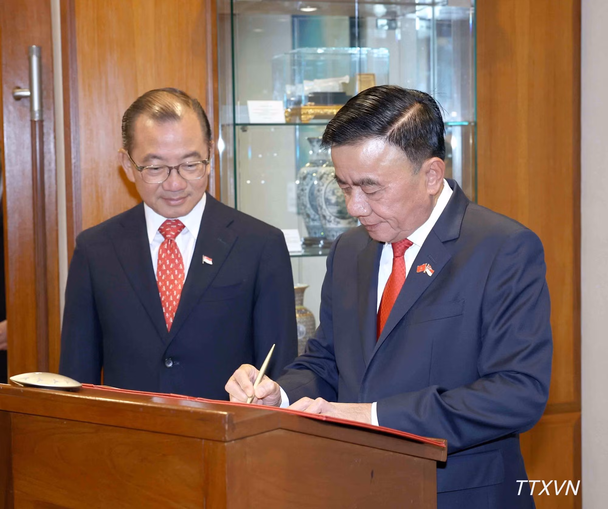 Cam Tu firma el libro de visitas del Parlamento de Singapur.