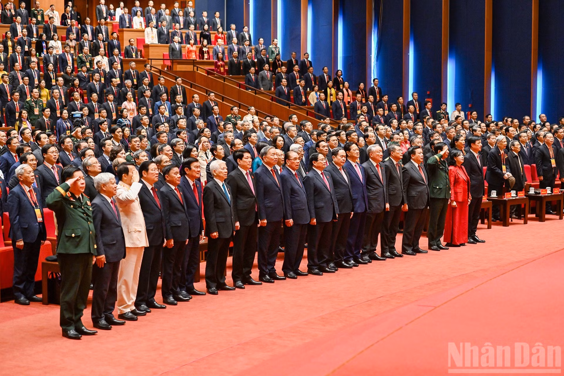 Delegados saludan la bandera nacional en la sesión de clausura.