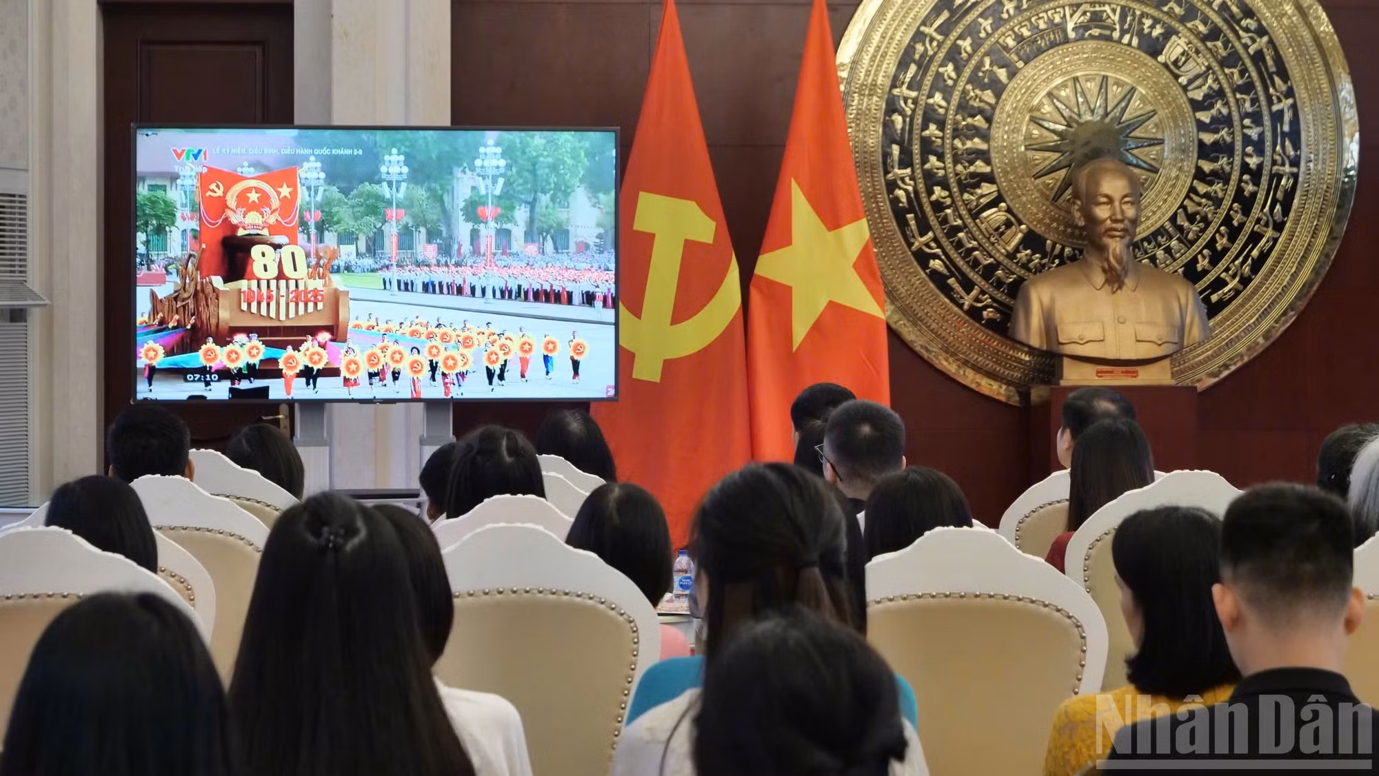 Delegados observan la ceremonia conmemorativa organizada en Vietnam a través de la pantalla.