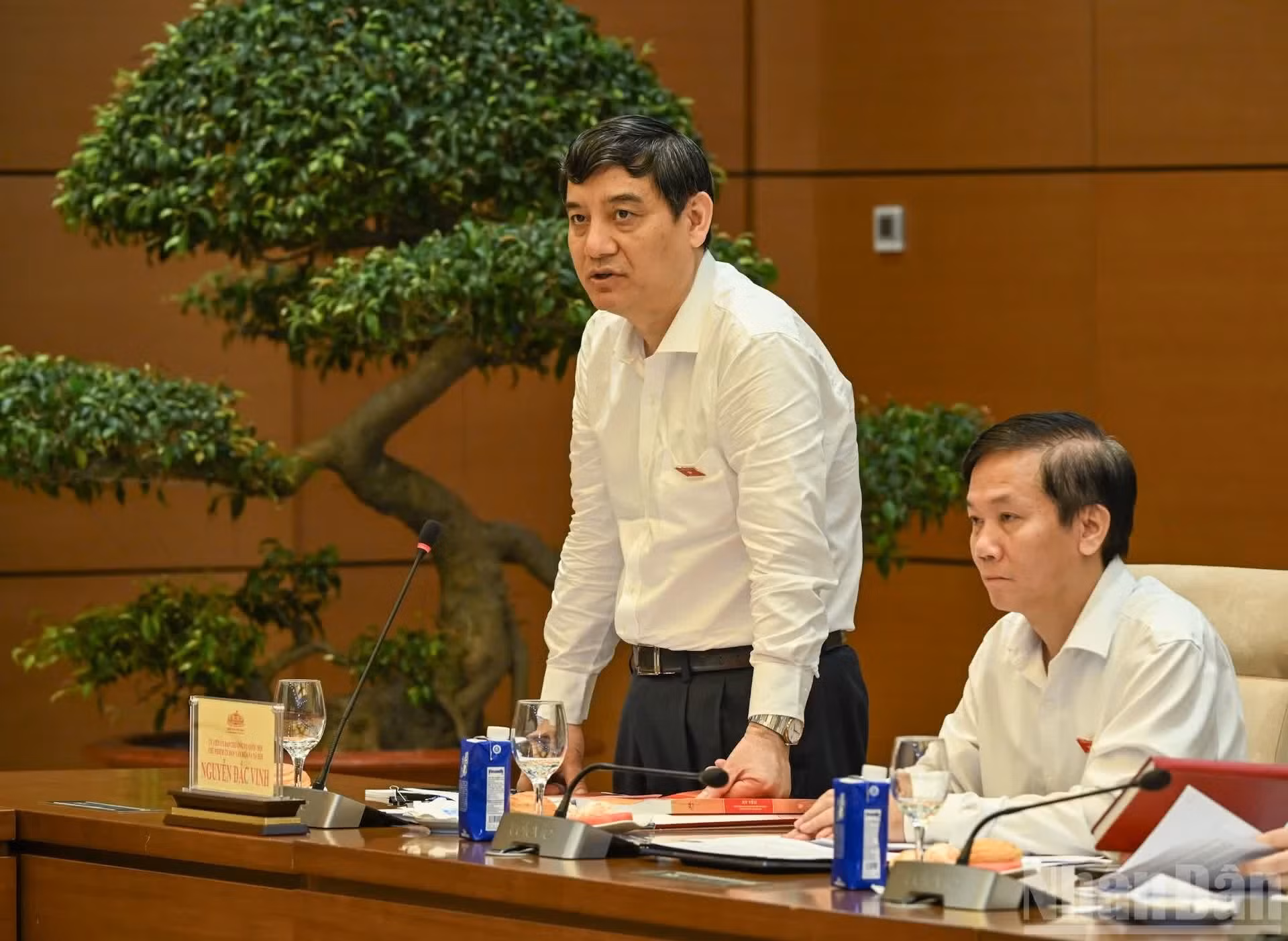 El jefe de la Comisión de Asuntos Socioculturales de la Asamblea Nacional, Nguyen Dac Vinh, presenta el informe en la sesión de trabajo.