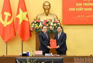 El secretario del Comité del Partido Comunista de Vietnam en la Asamblea Nacional y presidente de esta, Tran Thanh Man (izquierda), entrega la decisión del Buró Político del Comité Central del Partido a Le Quang Manh.