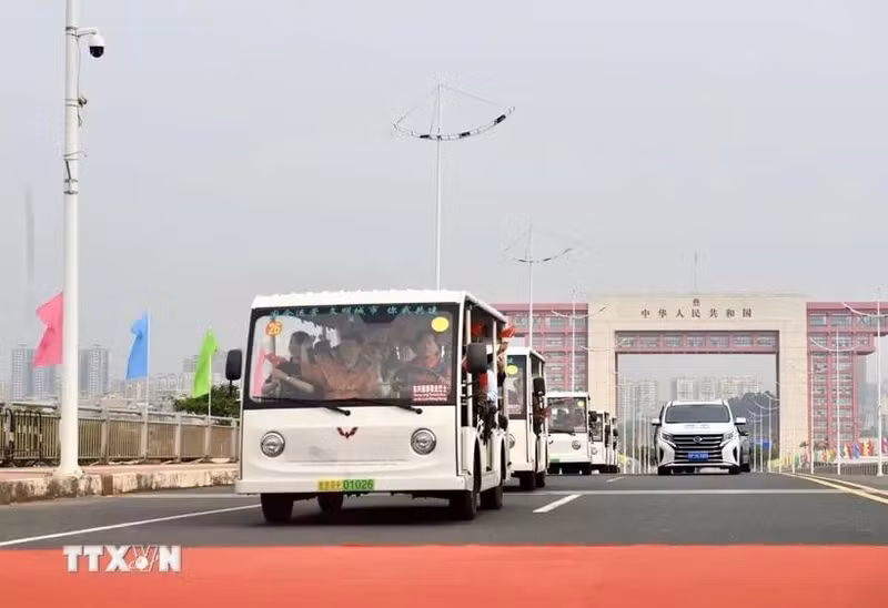 Los vehículos eléctricos que transportan a los turistas pasan por la línea divisoria del puente Bac Luan II (Foto: VNA)