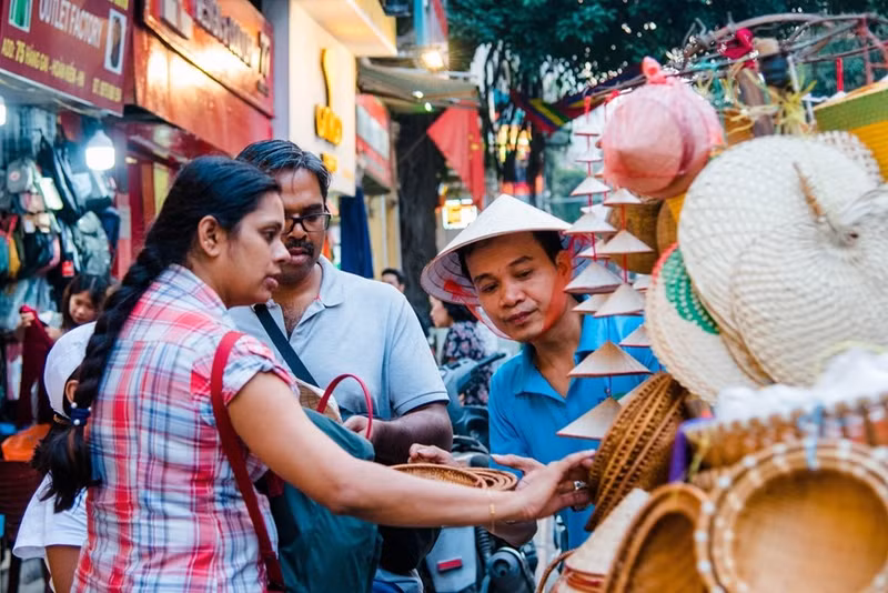 Turistas extranjeros compran souvenirs en Hanói.