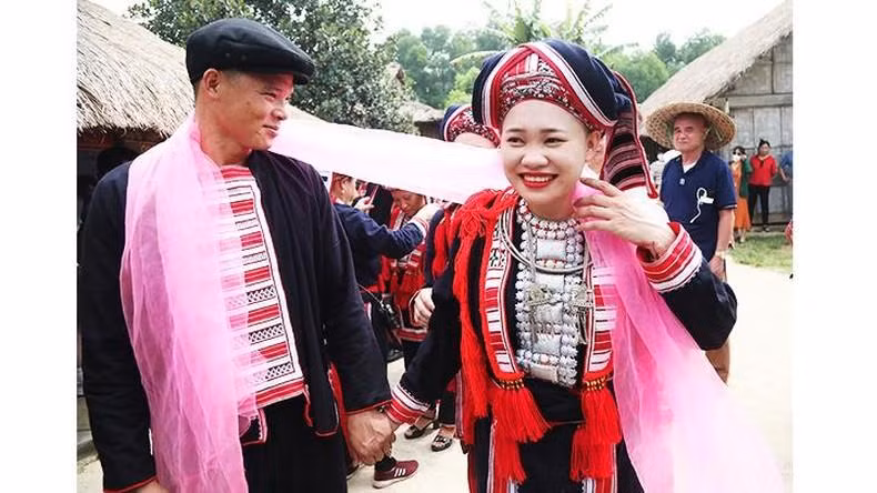 La joven pareja se ata el pañuelo rojo, que representa un lazo para crear un matrimonio duradero.