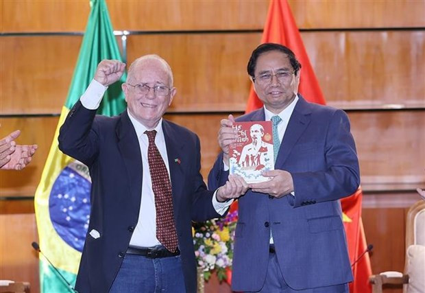 El secretario general de la Asociación de Amistad Brasil-Vietnam, Pedro de Oliveira, entrega al primer ministro Pham Minh Chinh el libro "Ho Chi Minh Vida e obra do lisder da lisder da libertação nacional do Vietnã" (Ho Chi Minh, la vida y obra del líder de la liberación nacional de Vietnam). (Foto: VNA)