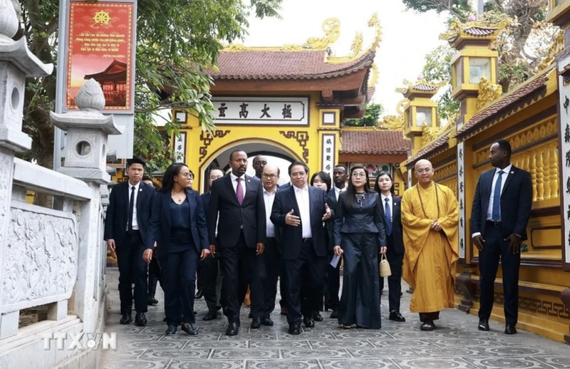 Los primeros ministros de Vietnam, Pham Minh Chinh, y de Etiopía, Abiy Ahmed Ali, junto con sus respectivas esposas, disfrutan de un recorrido por el espacio cultural y arquitectónico de la Pagoda Tran Quoc. (Foto: VNA)