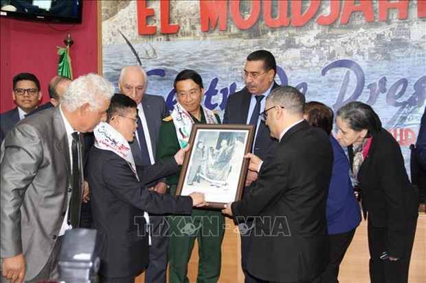 El embajador vietnamita en Argelia, Tran Quoc Khanh, regala al director general del periódico El Moudjahid, Brahim Takheroubt, una foto del General Vo Nguyen Giap entregando la bandera de Vietnam al ministro de Defensa de Argelia en 1976 (Foto: VNA) 