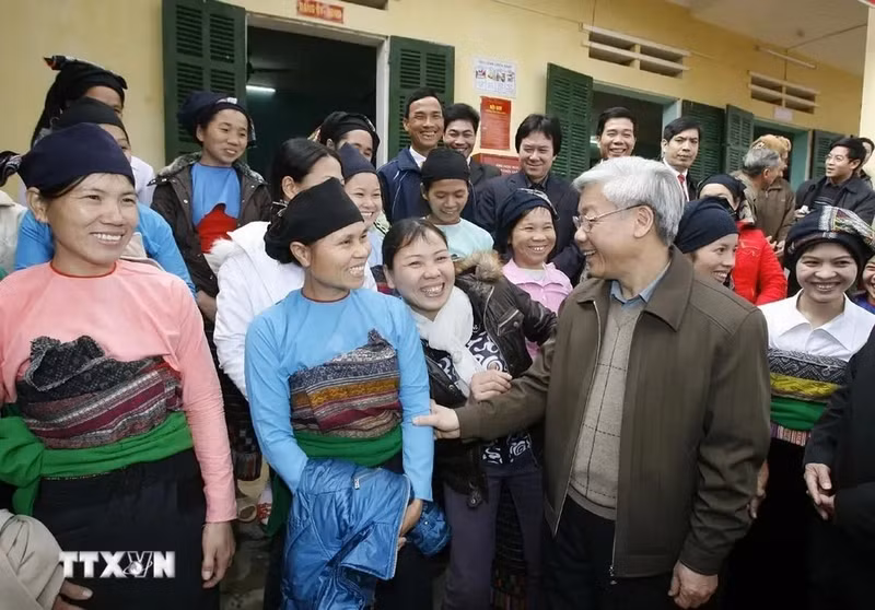 El presidente de la AN, Nguyen Phu Trong, con personas étnicas en la comuna de Ngoc Phung, distrito de Thuong Xuan, provincia de Thanh Hoa, enero de 2010. (Foto: VNA)