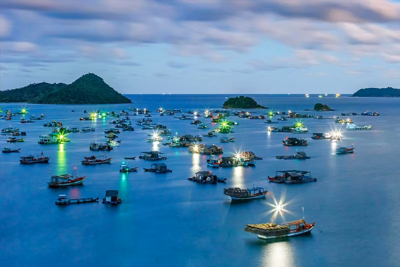 Un rincón de la isla Nam Du con un mar azul lleno de barcos de pescadores.