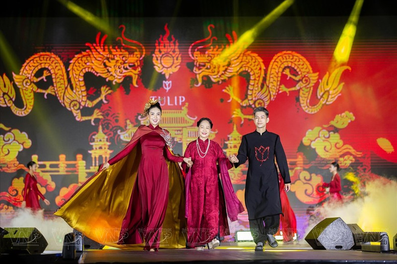 El diseñador Dung Nguyen y sus obras exhibidas por la artista popular Thu Quynh y la presentadora Mai Ngoc en el lanzamiento de la colección "Chon Kinh Ky" (Ciudad capital) 