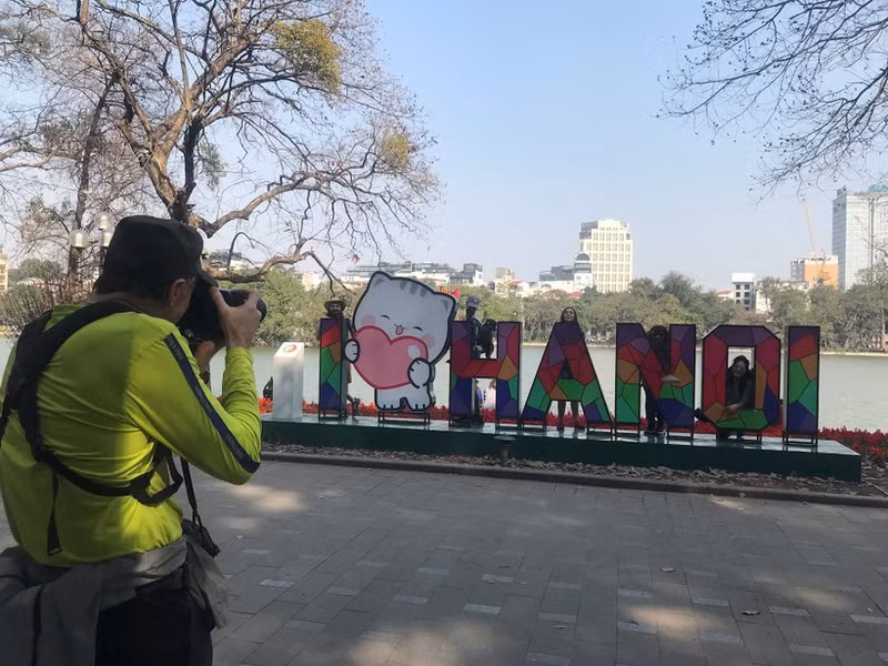 Turistas extranjeros en el lago Hoan Kiem, en Hanói (Foto: daidoanket.vn)