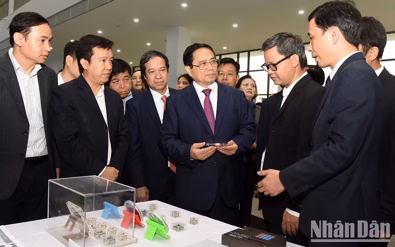 El jefe de Gobierno vietnamita visita el pabellón de exhibición de productos de microchip investigados y fabricados por estudiantes del Instituto de Tecnología de la Información de la Universidad Nacional de Hanói.
