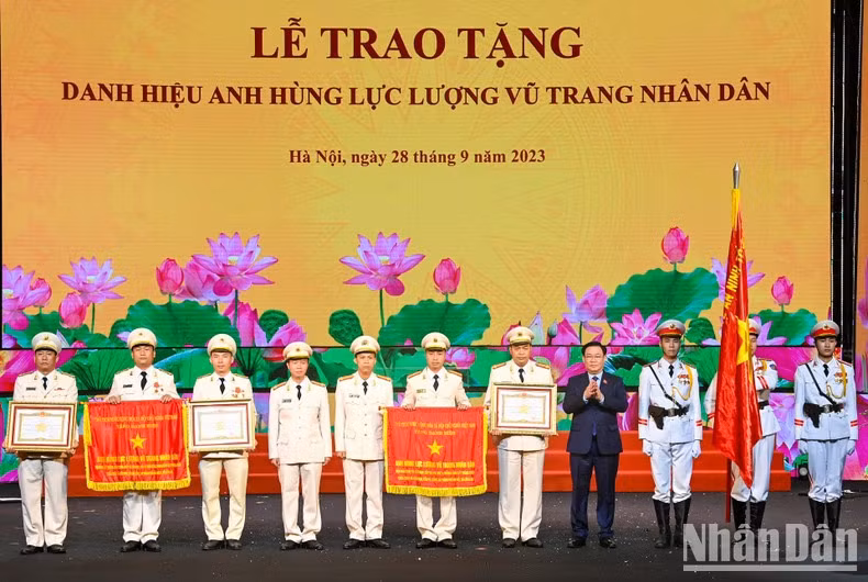 El presidente de la Asamblea Nacional, Vuong Dinh Hue, entrega el título de "Héroe de Fuerzas Armadas Populares" a colectivos e individuos destacados.