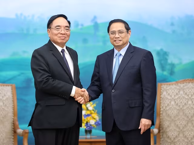 El primer ministro Pham Minh Chinh recibe al ministro de Planificación e Inversión de Laos, Khamchen Vongphosy. (Foto: VNA)