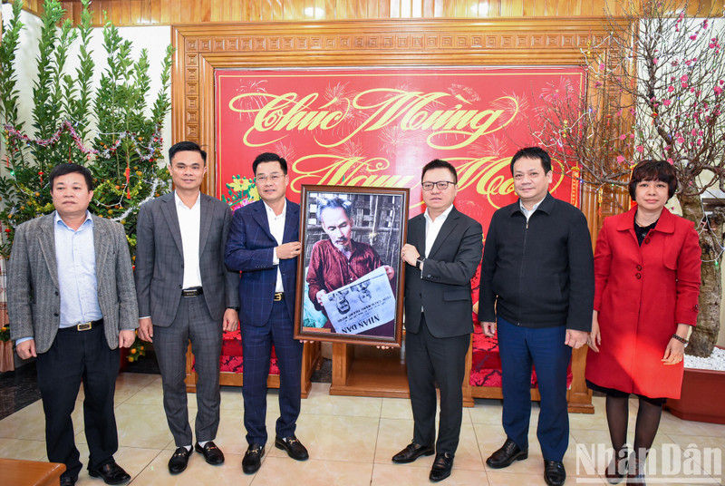 Le Quoc Minh, presidente-editor del periódico Nhan Dan, entrega una foto del Tío Ho a los oficiales y soldados de la entidad militar.
