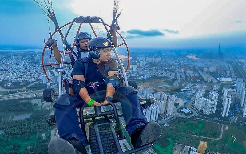 Turistas contemplan Ciudad Ho Chi Minh desde las alturas con parapentes