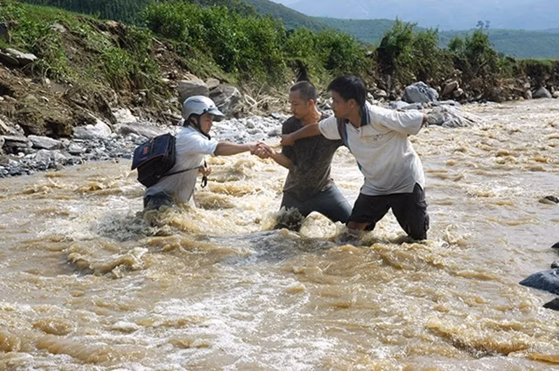 El periodista de la Agencia Vietnamita de Noticias Xuan Truong y sus colegas trabajan en medio de una inundación en la provincia de Lao Cai, en 2008.