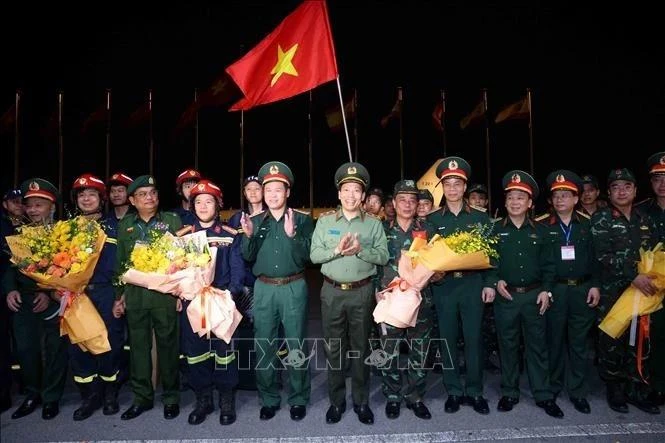 El teniente general Vu Hai San, viceministro de Defensa, y el teniente general Le Van Tuyen, viceministro de Seguridad Pública, dan la bienvenida a las fuerzas de rescate que acaban de regresar de Myanmar tras completar su misión internacional. (Fotografía: VNA)