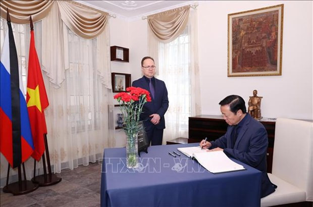 El vice primer ministro Tran Hong Ha escribe en el libro de condolencias. (Fotografía: VNA)