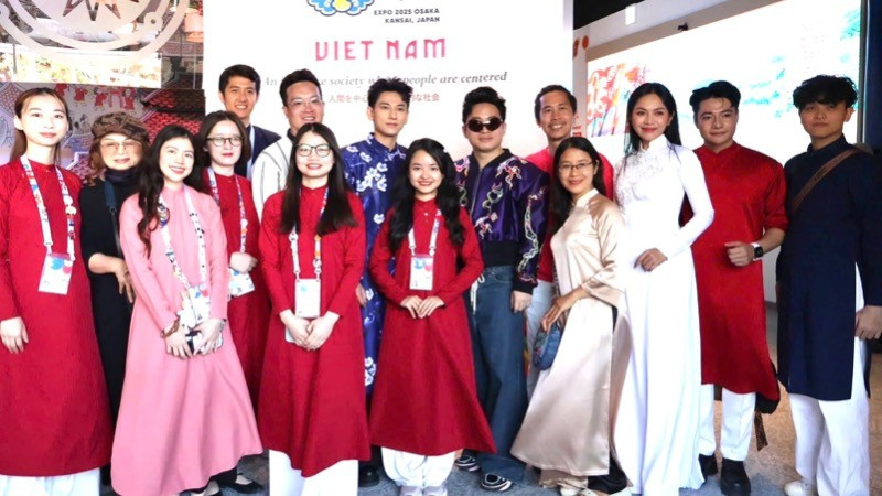 Los artistas vietnamitas se toman fotos en el pabellón de su país en la EXPO 2025. (Fotografía: Nhan Dan)