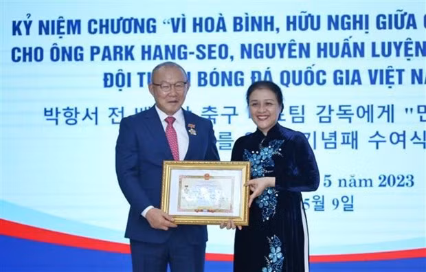 La presidenta de la Unión de Organizaciones de Amistad de Vietnam, Nguyen Phuong Nga, entrega la distinción a Park Hang-seo, exentrenador de la selección nacional de fútbol. (Fotografía: VNA)