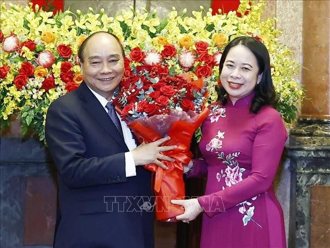 La presidenta interina Vo Thi Anh Xuan entrega flores a Nguyen Xuan Phuc. (Fotografía: VNA)