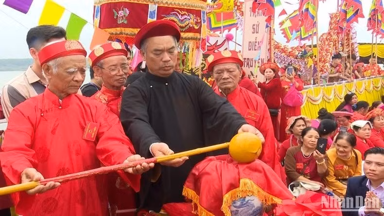 Dang Vu Tran Nha, custodio del Templo Tran en Thai Binh, vierte agua recogida desde el río al jarrón.