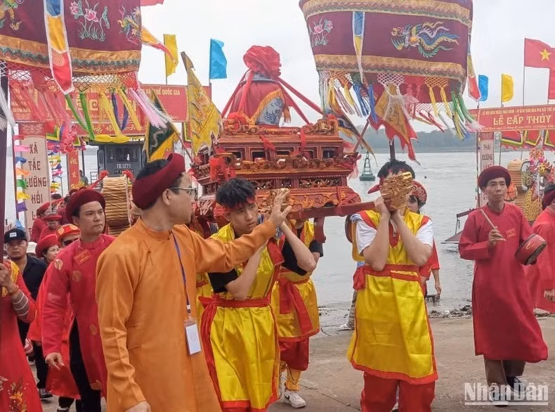 Jóvenes en la comuna de Tien Duc llevan al Templo Tran la litera en que se coloca el jarrón de agua.