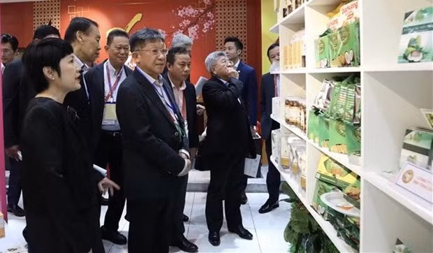 Los visitantes observan productos vietnamitas exhibidos en la conferencia. (Fotografía: VNA)