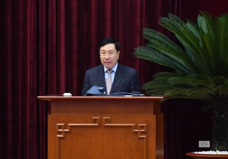 El miembro del Buró Político y vice primer ministro permanente, Pham Binh Minh, presenta un informe.